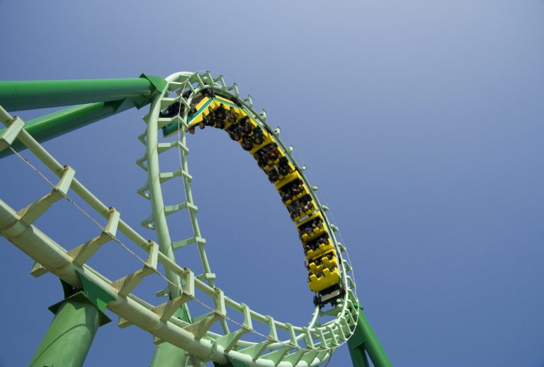 Green roller coaster loop providing ASTM F2291-21 amusement ride patrons with safe thrills.