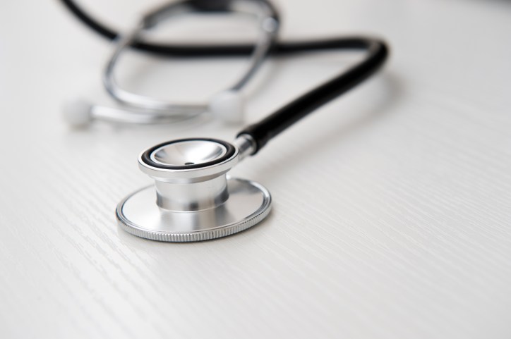 Stethoscope on wood adhering to ISO 15223-1:2021 for symbols on medical device labels.