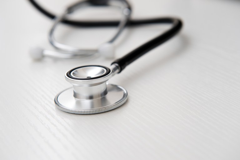 Stethoscope on wood adhering to ISO 15223-1:2021 for symbols on medical device labels.