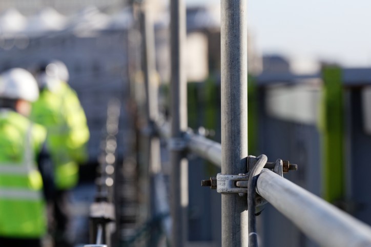 Steel scaffolding of construction site at height that workers need ANSI/ASSP Z359.14-2021 self-retracting devices.