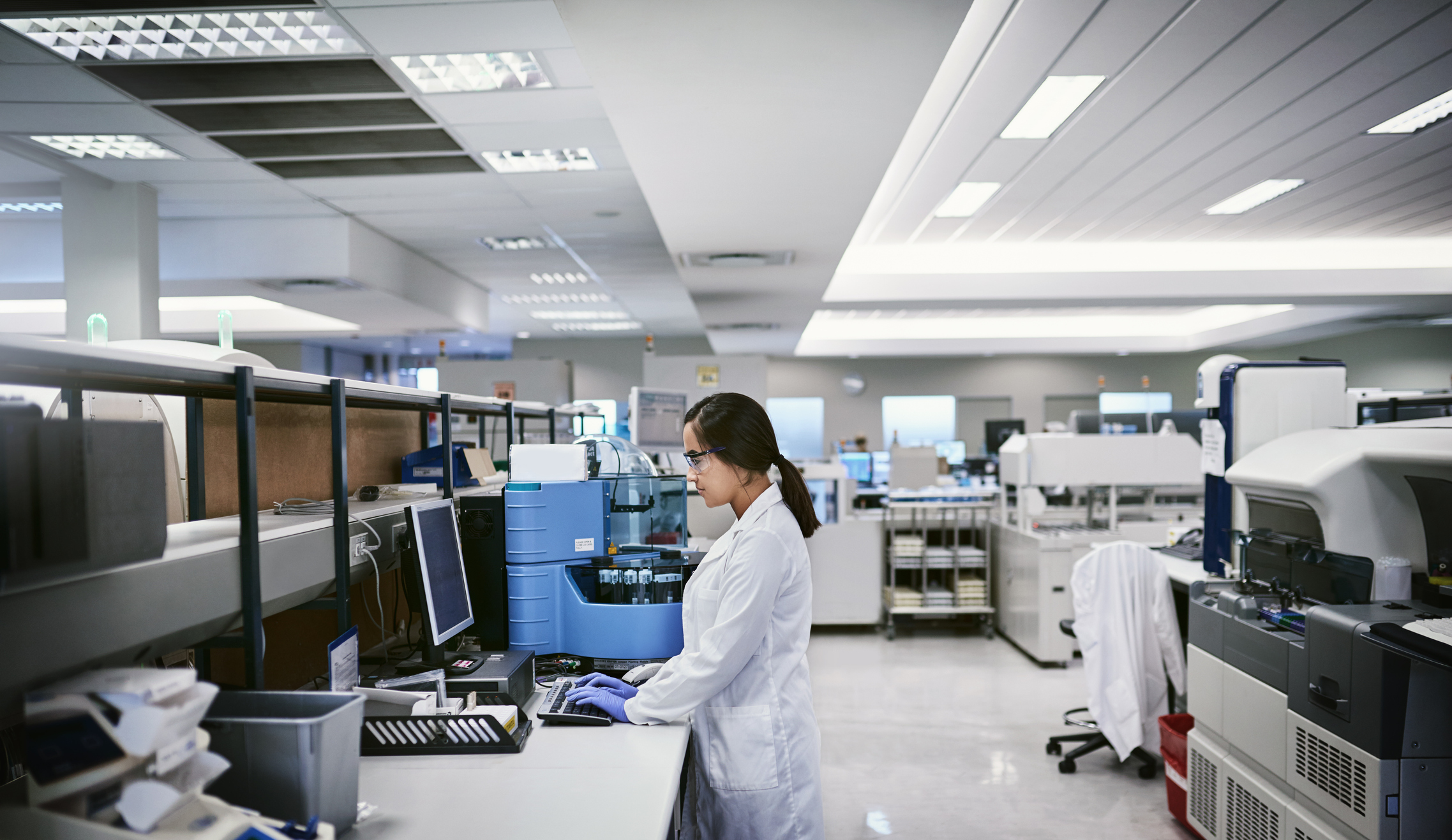Woman working alone in laboratory with resilient and stable practices during the pandemic with ANAB accreditation.