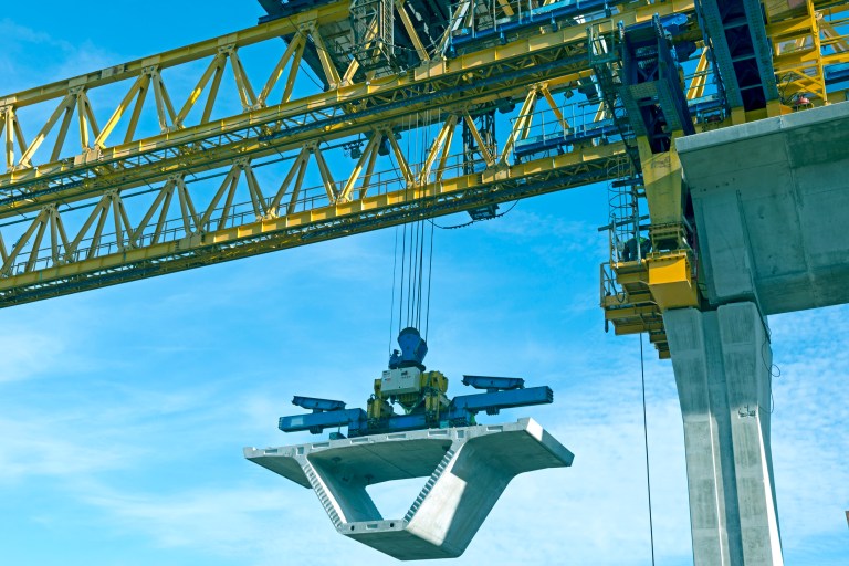 Below the hook lifting devices following ASME B30.20-2021 under yellow tower crane.