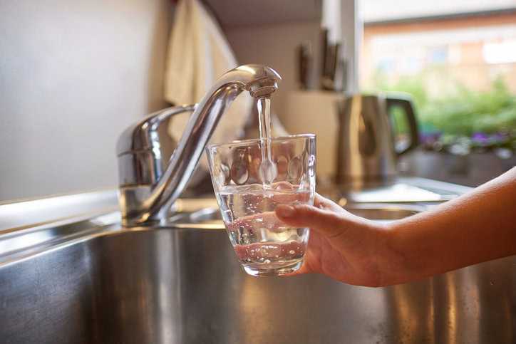 Clear, healthy drinking water flowing into glass with no negative health effects thanks to NSF/ANSI 60-2024 for chemicals.