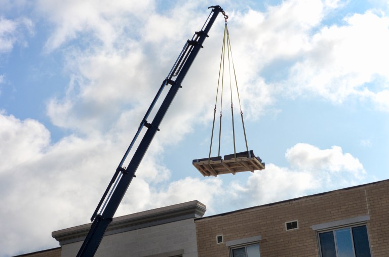 An ASME B30.9-2021 sling pulling up platform in work site.
