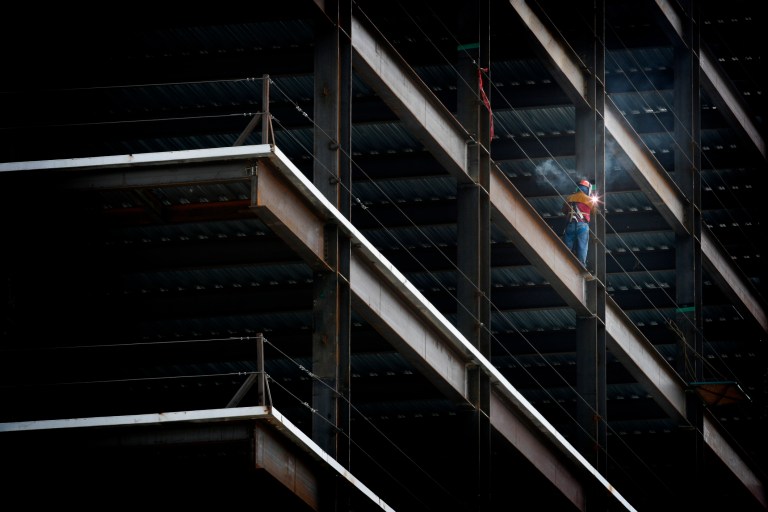A construction working on constructing a dark building that follows ASCE/SEI 7-2022.