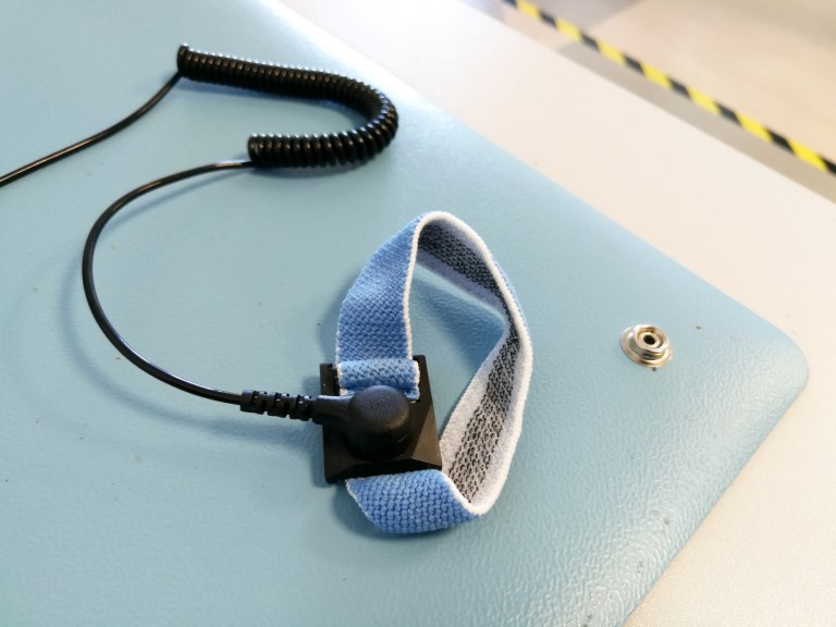 A blue ANSI/ESD S1.1-2021 wrist strap ready to ground a worker to prevent static and electrostatic discharge.