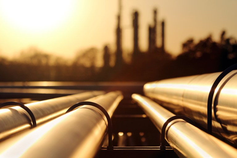 Two API 579-1/ASME FFS-1-2021 pipes in sunset lead into petrochemical plant to provide fitness-for-service.
