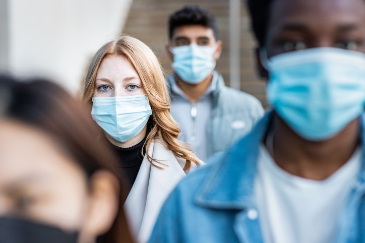 A crowd of people wearing masks because of the pandemic.