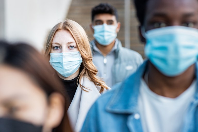 A crowd of people wearing masks because of the pandemic.