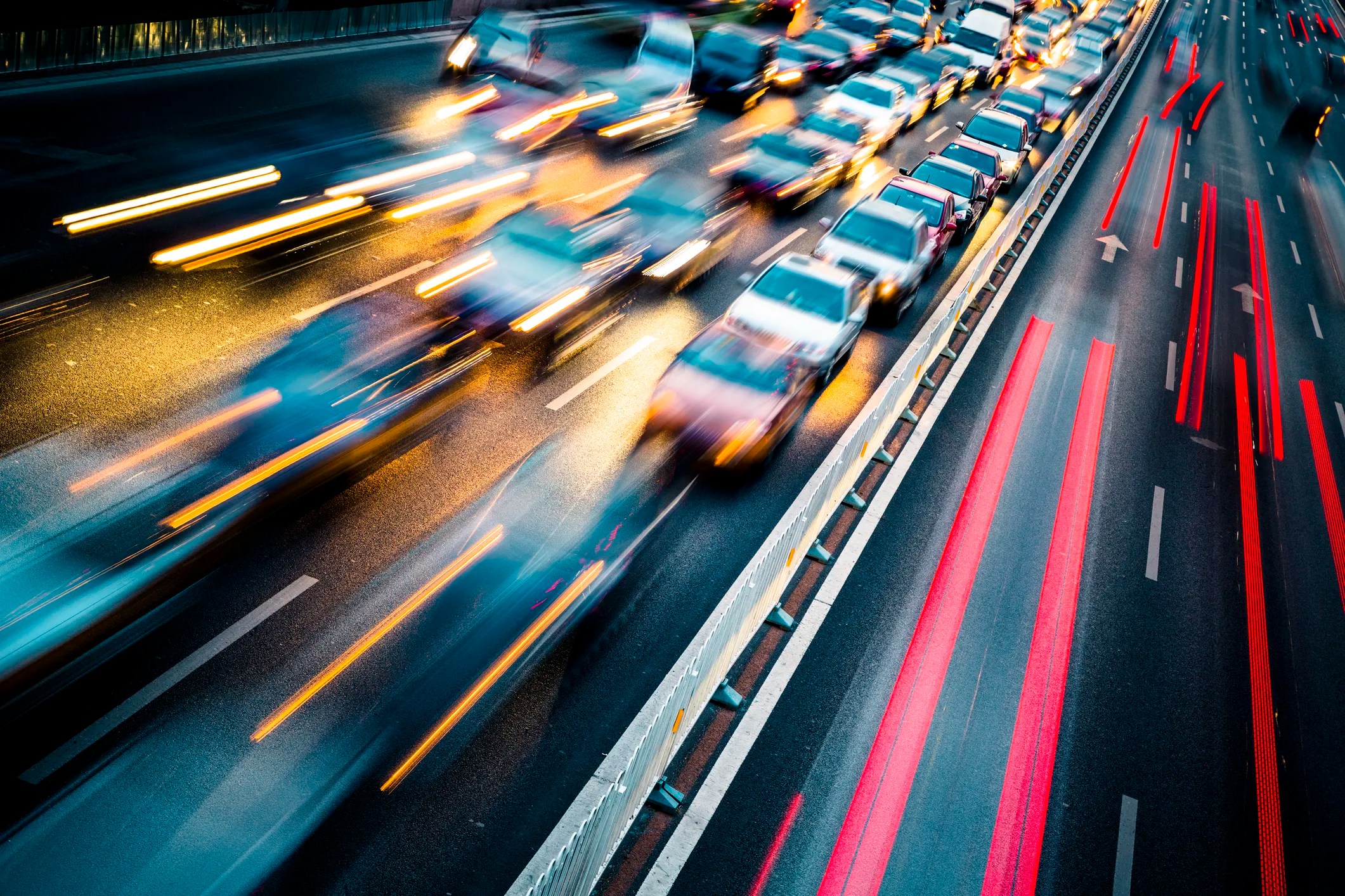 Lights streaking from moving cars in city traffic, spreading ANSI/IES RP-8 streetlights