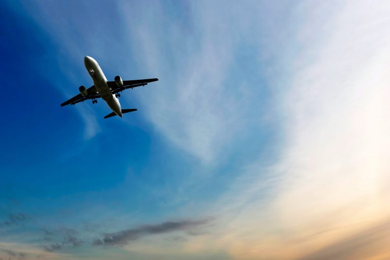 Airplane soaring high in the sky due to adherence to AS9104 changes to aerospace quality management systems.