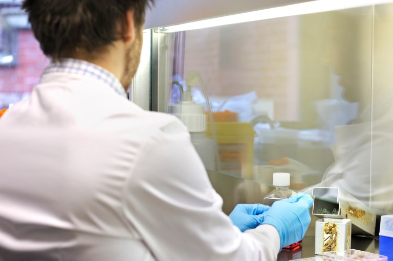 Man working with ANSI/ASHRAE 110 chemical fume hood and ANSI/AIHA/ASSE Z9.5 laboratory ventilation measures.