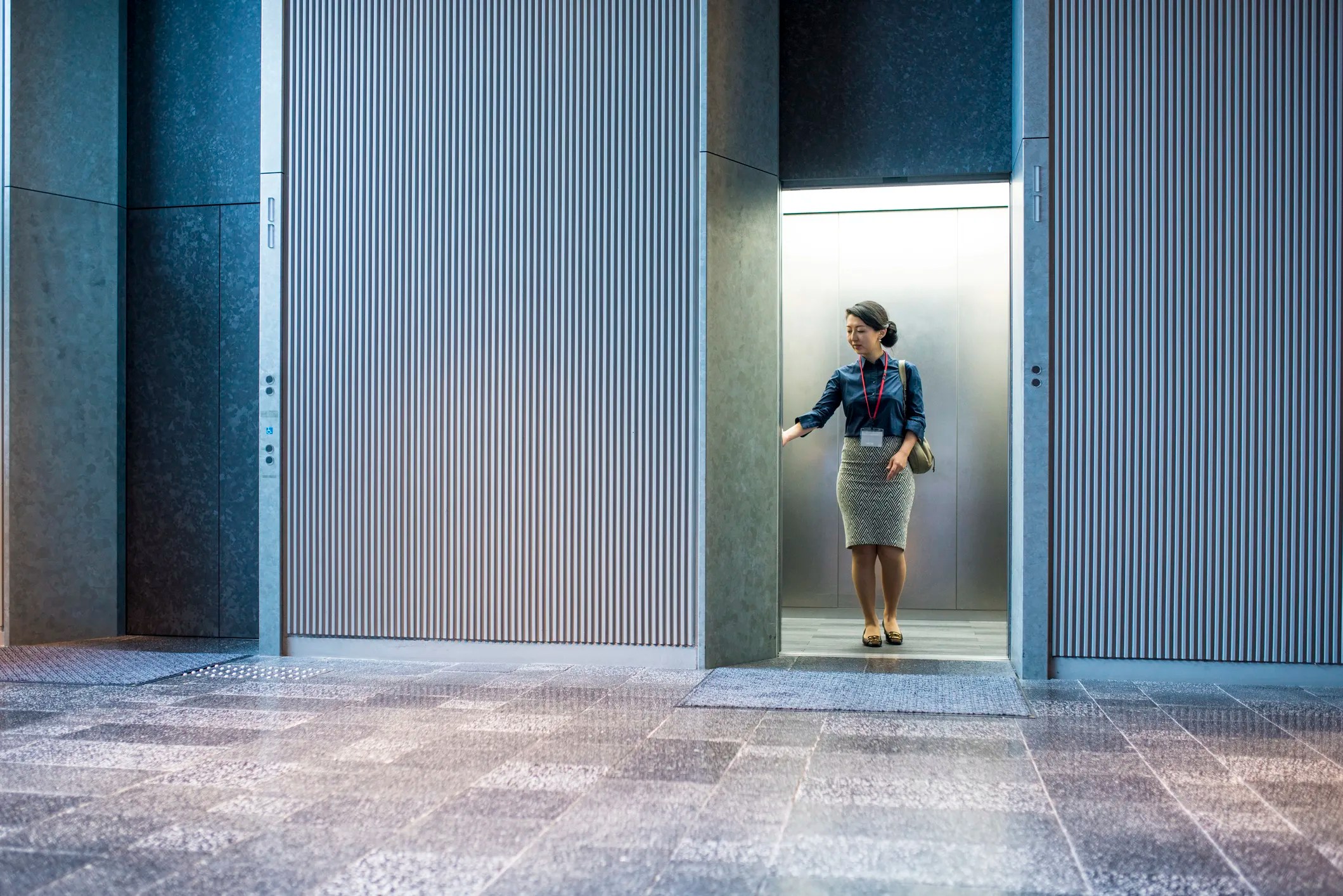 Woman getting in elevator adhering to ASME A17.1 and benefitting from a long history.