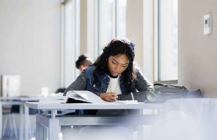 Young woman focused in school and studying to complete her certification as an alternative credential.