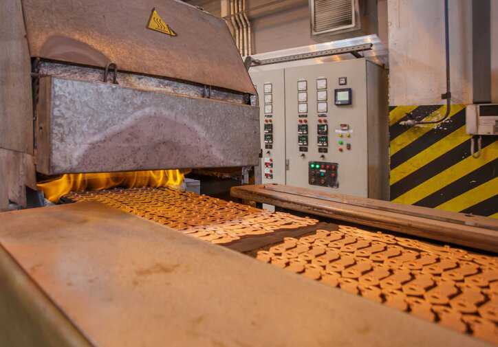 Combustible copper metal parts in high-temperature sintering process adhering to ISO 5755:2022.