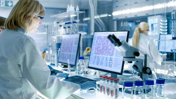 Laboratory scientist inspecting tissue specimens for research at a biobank, adhering to ISO 20387:2018.