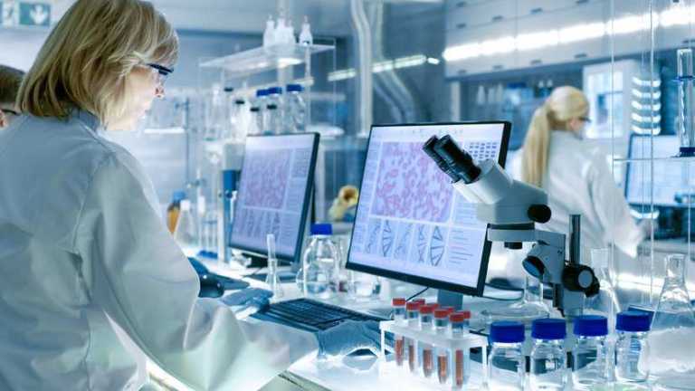 Laboratory scientist inspecting tissue specimens for research at a biobank, adhering to ISO 20387:2018.