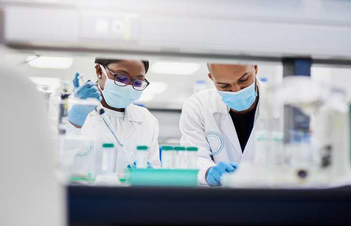 Two scientists working with pipettes to adhere to 21 CFR Part 58 GLP for their nonclinical lab.