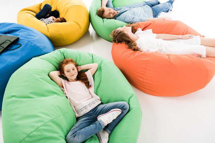 Family resting on safe bean bag chairs and covers that adhere to ASTM F1912-21.