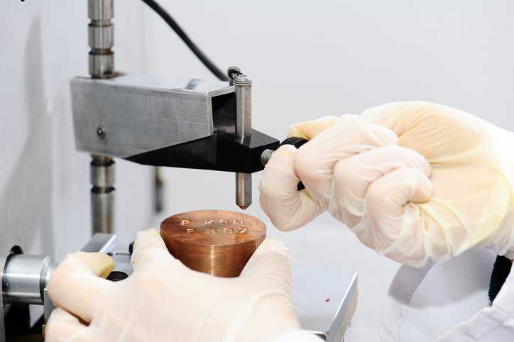 Laboratory assistant performing a microindentation test adhering to the ASTM test method in ASTM E384-22.