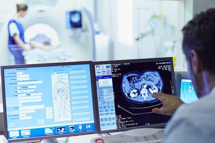 Doctor examining medical electrical equipment with graphical symbols that adhere to IEC/TR 60878:2022.