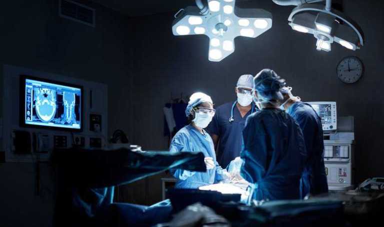Surgeons operating in a medical laboratory adhering to ISO 15189:2022 quality management and requirements.