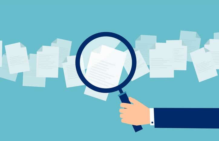 Cartoon hand performing common ISO assessment and audit performance techniques on evidence documents.