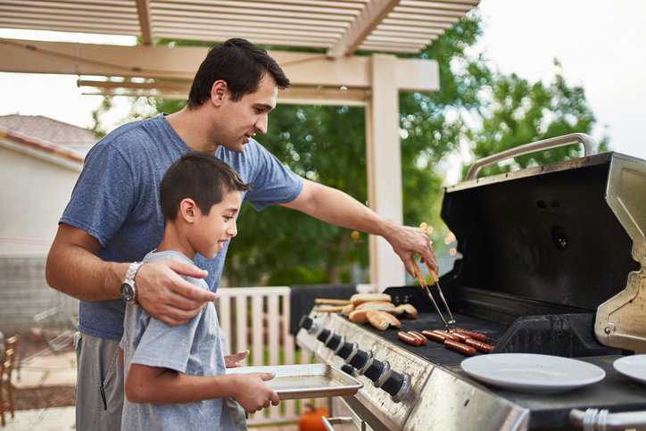Father showing son outdoor cooking appliances adhering to CSA/ANSI Z21.58-22.