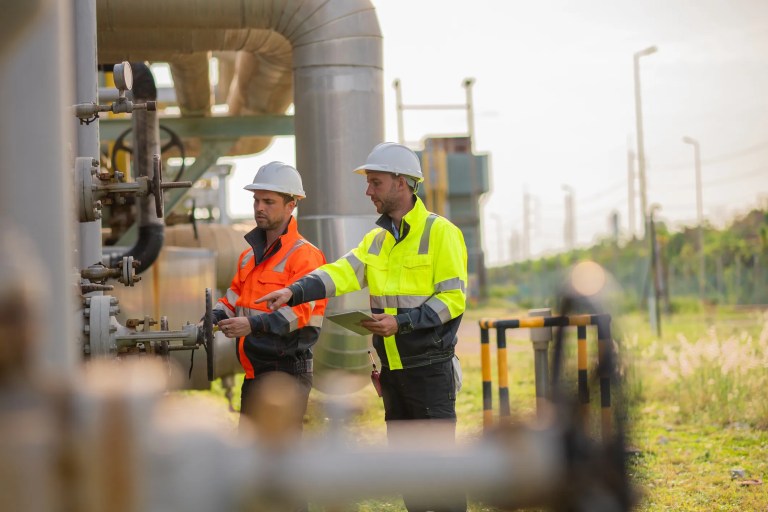 Engineers inspection an ASME B31.8-2022 piping system schematic for gas transmission and distribution.