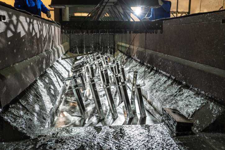 Steel getting covered in zinc coating for corrosion prevention, adhering to ASTM B633-23.