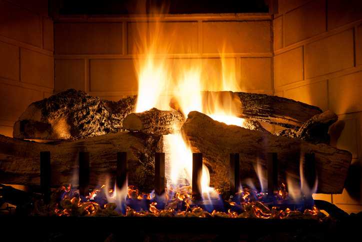 A nighttime fire is lighted in a ANSI Z21.88-2019 gas fireplace