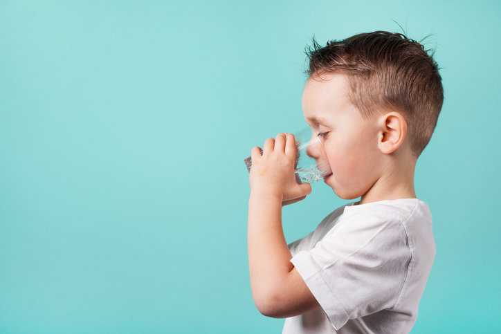 A boy hydrating with drinking water after being treated for NSF/ANSI 53-2022 health effect units.