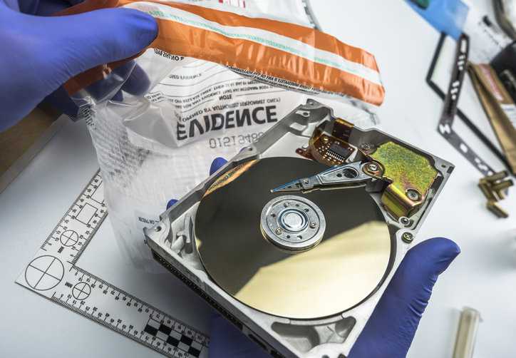 Forensics expert analyzing hard drive evidence in criminal justice lockup.