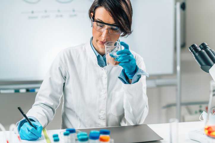 Sensory assessor performing sensory analysis of sea fish sample in a test tube that adheres to ISO 8586:2023.