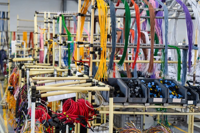 Wire and cable harness assemblies in a factory that adhere to IPC/WHMA A-620E-2025 guidelines.