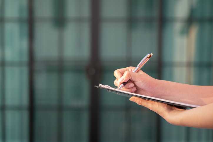 Completing a checklist in front of a green background.