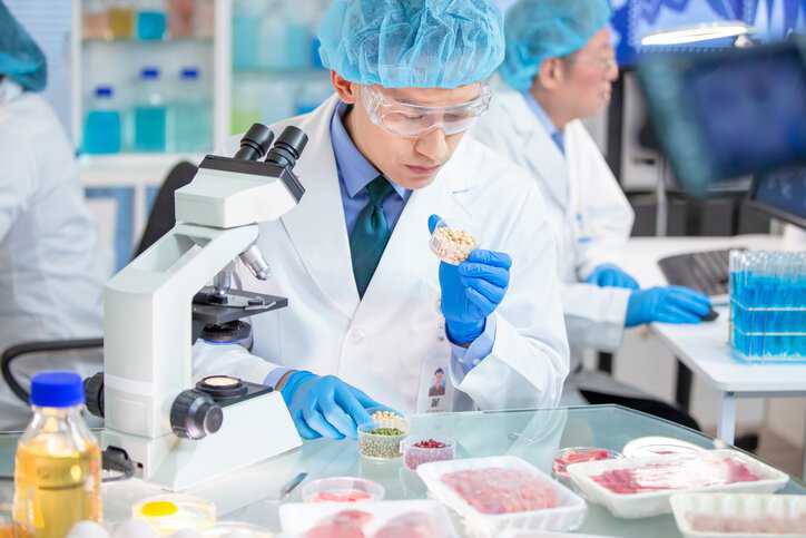 Researcher performing microbiological examinations on meat that adhere to ISO 6887-1:2017.