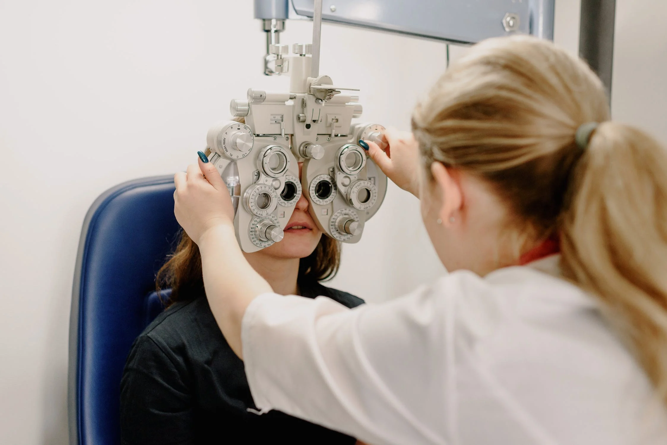 Woman getting eyes checked with optical devices for low vision that adhere to ANSI Z80.9-2020.