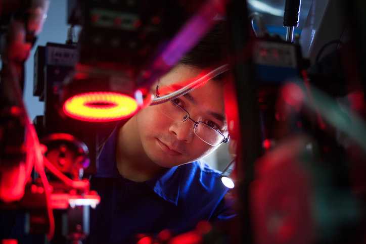 Man inspecting bright machinery and adhering to ANSI B11.0-2023 for safety.