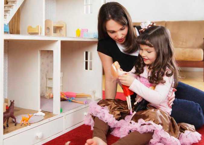 A child and her mom playing with Barbie dolls that adhere to ISO 8124-6:2018 toy safety specifications.