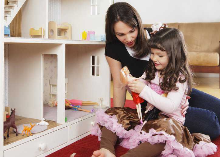 A child and her mom playing with Barbie dolls that adhere to ISO 8124-6:2018 toy safety specifications.