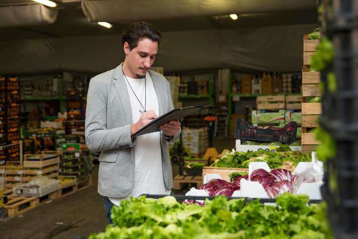 ANAB Accreditor for Food Safety Management Systems Certification (ISO 22000 and FSSC 2200) checking lettuce and cabbage for bacteria.