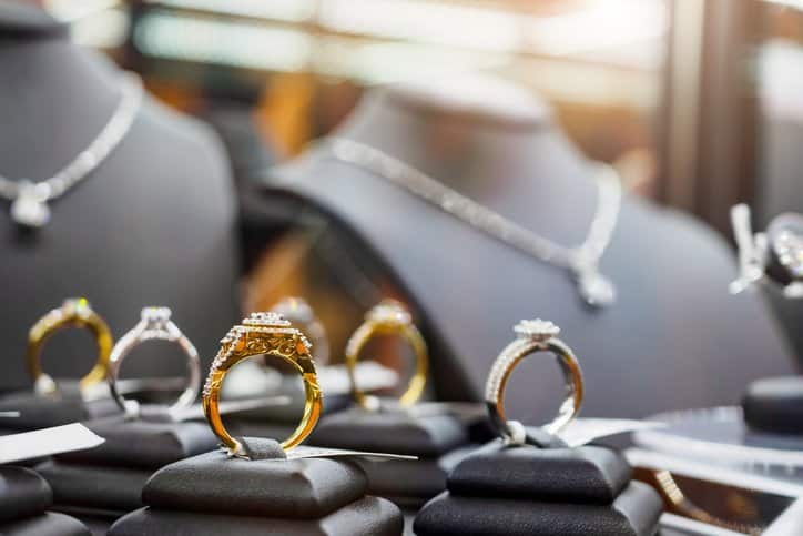 Gold and silver metal alloy jewelry shown in luxury retail store adhering to ISO 22764:2020.
