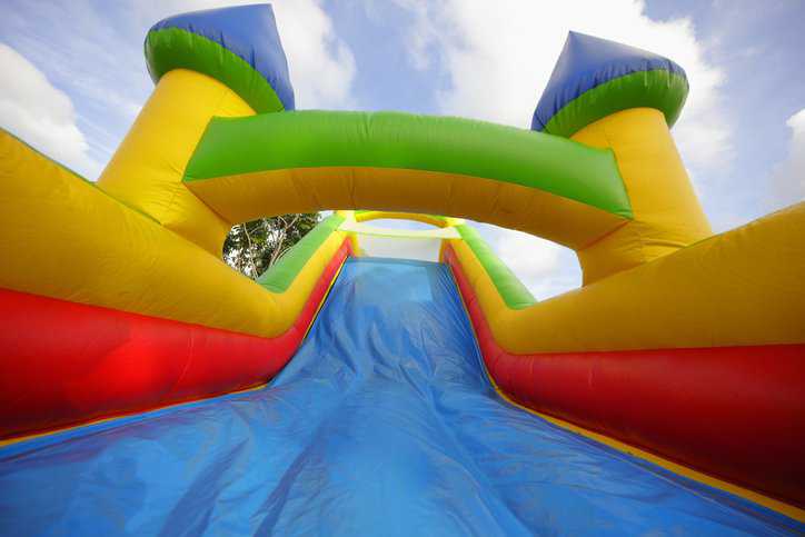 Colorful bouncy house at amusement park adhering to ASTM F2374-22.