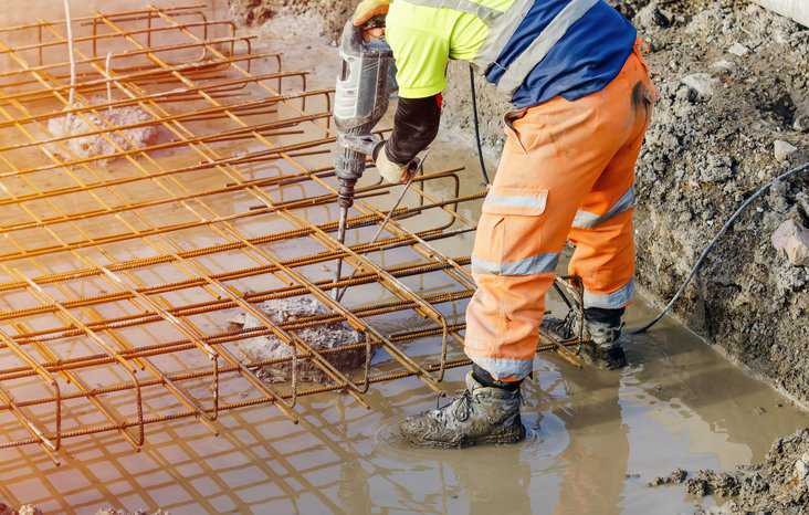 Builder using loud machinery for breaking concrete with noise adhering to ASA/ANSI S12.3-2023.