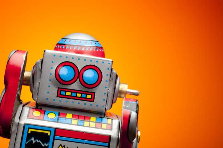 Retro toy robot on orange background that might be too old to follow ASTM F963-23 toy safety standard requirements.