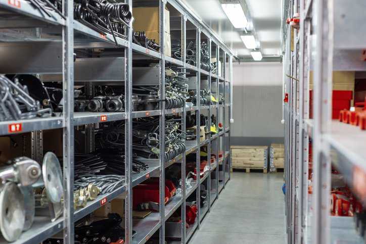Factory warehouse spare parts in steel industrial storage racks adhering to ANSI MH16.1-2023.