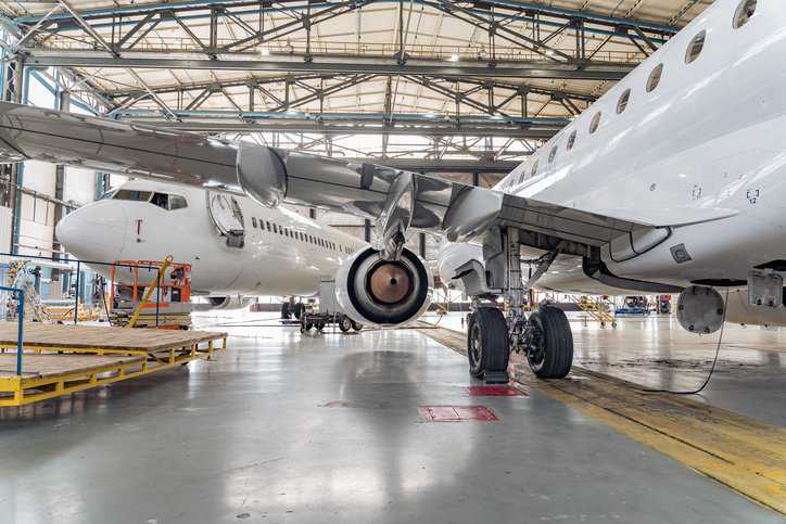Passenger airplane on maintenance repair check in airport hangar needing structural adhesive bonding that adheres to ASTM D3933-98(2017).
