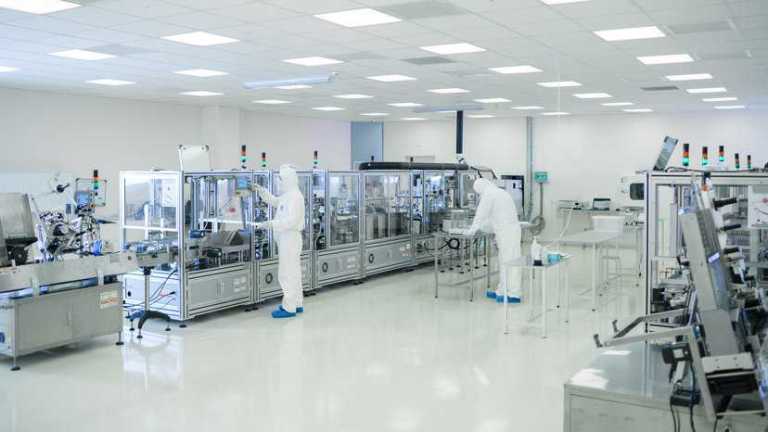 Sterile high precision laboratory with technicians checking equipment with IQ/OQ/PQ qualification.