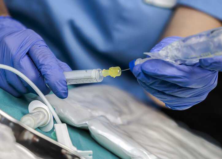 Nurse preparing medication for bloodstream infection in a hospital with an intravascular catheter, which adheres to ISO 10555-1:2023.